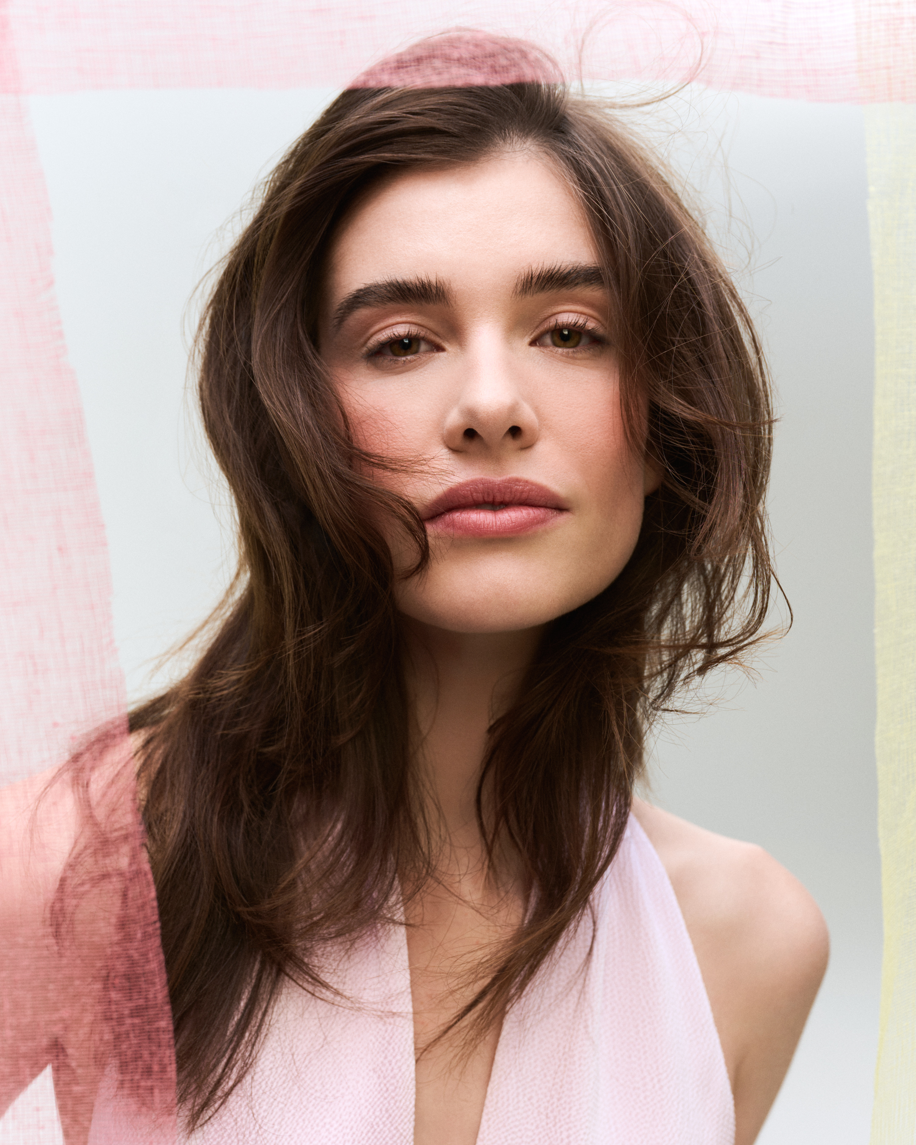 Vrouw met nude make-up en bloemetje in de mond