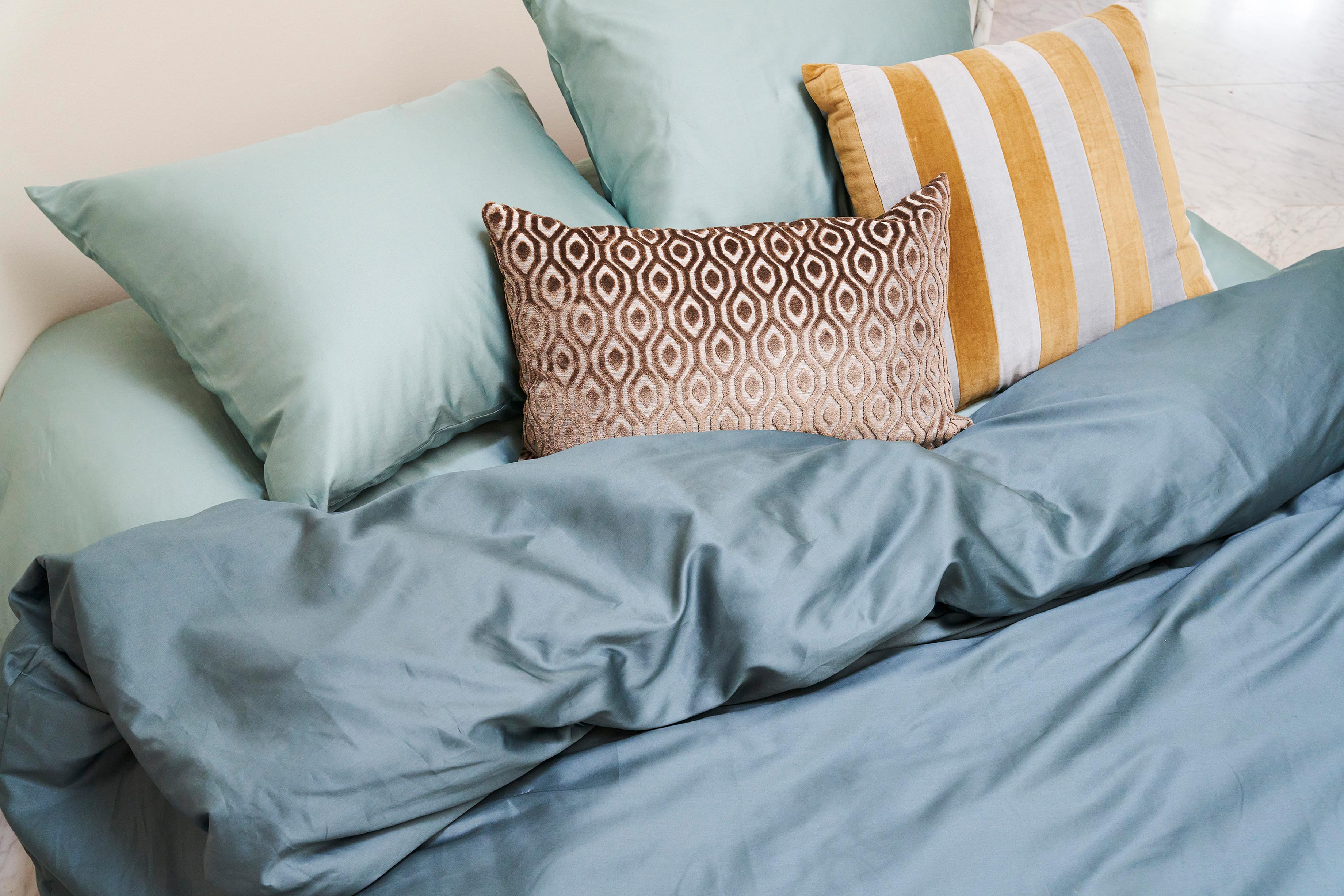 Sierkussens van HKliving en HAY op bed 