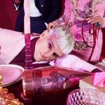 Extravagante roze eettafel en man met bijpassende outfit en makeup
