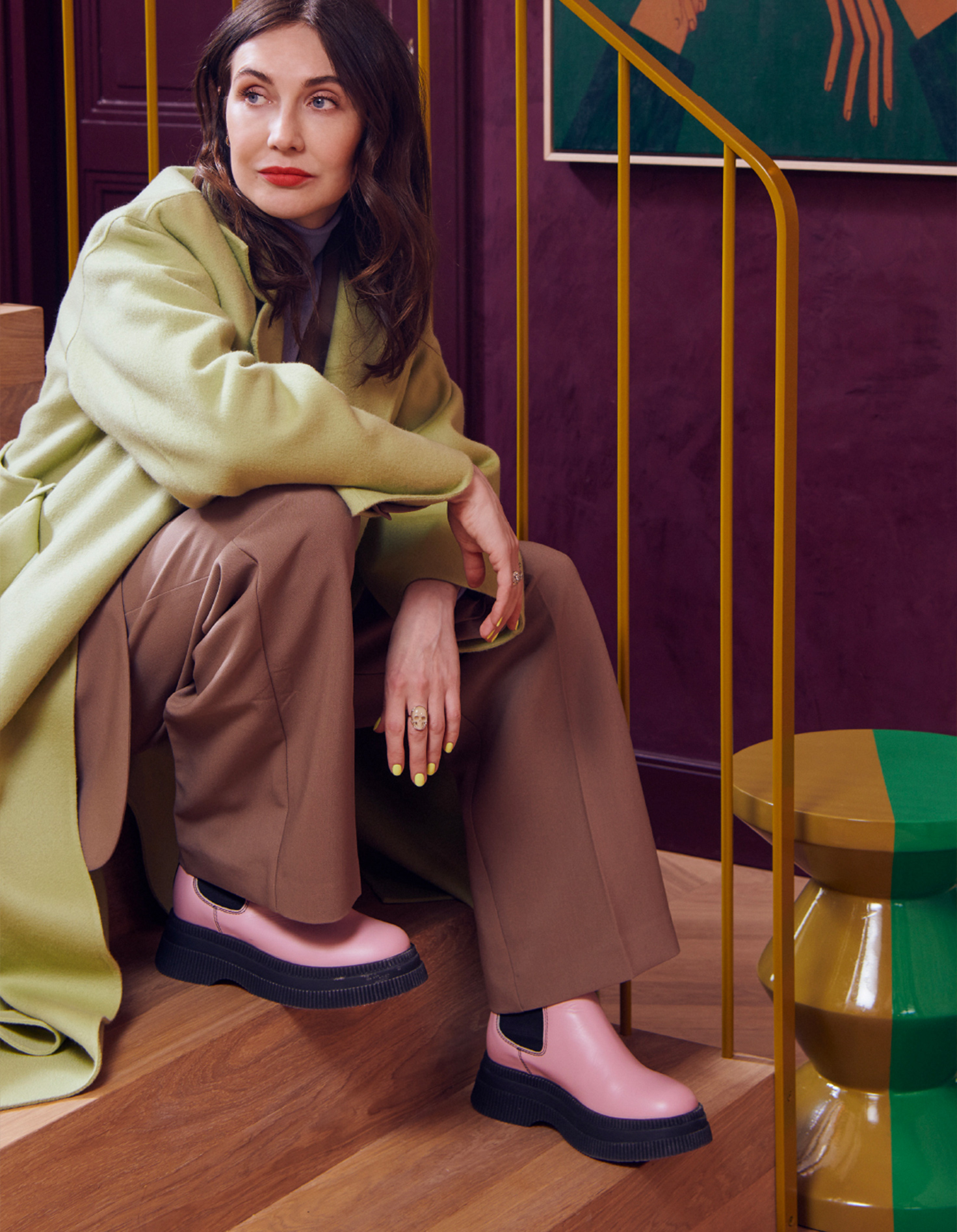 Carice van Houten op een stijlvolle trap in een kleurrijk interieur